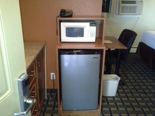 a microwave sitting on top of a table with a refrigerator at Economy Inn Tonawanda in Tonawanda