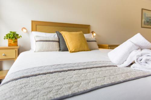 a bedroom with a large bed with towels on it at Fox on the Run - Motel Kilmore in Kilmore