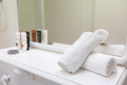 Baño con 2 toallas en una encimera frente a un espejo en Fox on the Run - Motel Kilmore, en Kilmore