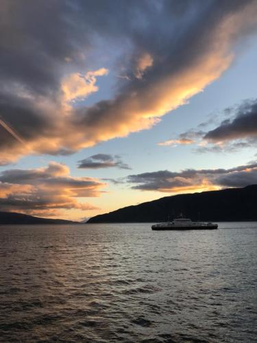 a boat on a large body of water at sunset at Sogn Hotel in Vadheim