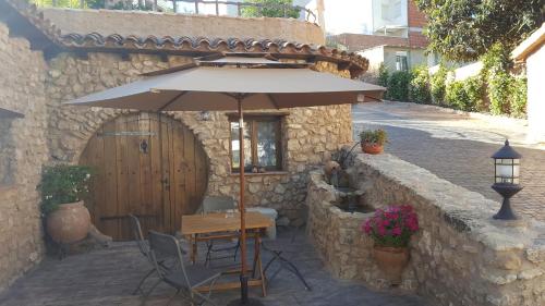 a table with an umbrella in front of a building at Casas Rurales Almoguer in Frailes