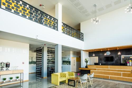 a view of the lobby of a building with yellow chairs at Mision Express Durango in Durango