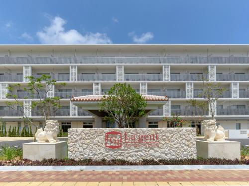 ein großes weißes Gebäude mit zwei Statuen davor in der Unterkunft La'gent Hotel Okinawa Chatan Hotel and Hostel in Chatan