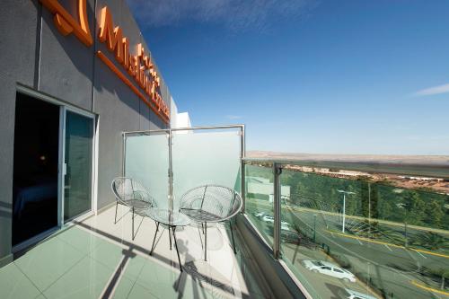 a balcony with two chairs on a building at Mision Express Durango in Durango