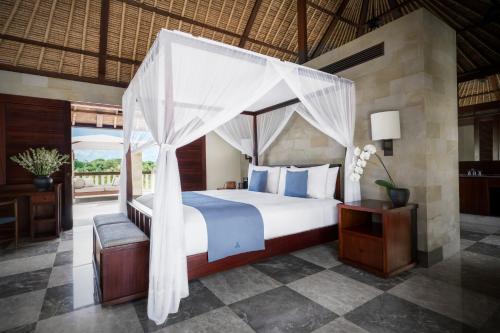 - une chambre avec un lit à baldaquin dans l'établissement REVĪVŌ Wellness Resort Nusa Dua Bali, à Nusa Dua