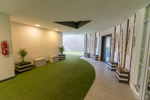 a hallway with a green carpet in a building at Suite de Lujo, Piso Alto, junto Parque Carolina, Generador electrico in Quito