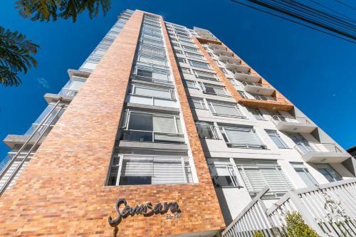 a tall brick building with a sign on it at Suite de Lujo, Piso Alto, junto Parque Carolina, Generador electrico in Quito