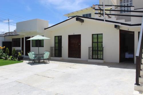 a house with a patio with a table and an umbrella at Hotel D'Lina Princess Suites in San Cristóbal de Las Casas