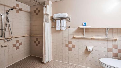 a bathroom with a shower and a toilet at SureStay Hotel by Best Western East Brunswick in East Brunswick