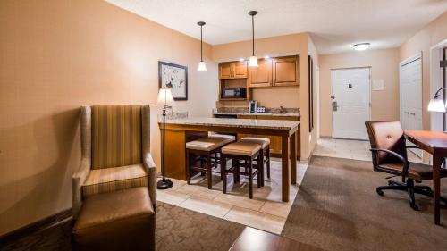 a living room and kitchen with a bar and chairs at The Inn at Lewisburg, BW Signature Collection in Lewisburg