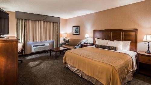 ルイスバーグにあるBest Western Plus Country Cupboard Innのベッドとテレビが備わるホテルルームです。
