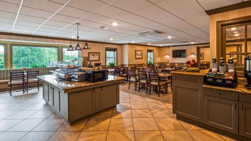 un ristorante con bar con tavoli e sedie di Best Western Plus Country Cupboard Inn a Lewisburg