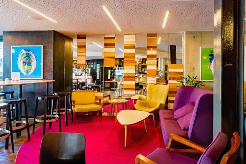 a restaurant with colorful chairs and a bar at BreakFree on Cashel in Christchurch