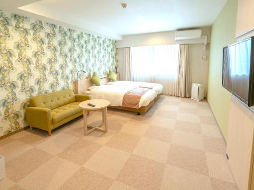 a hotel room with a bed and a couch at La'gent Hotel Okinawa Chatan Hotel and Hostel in Chatan