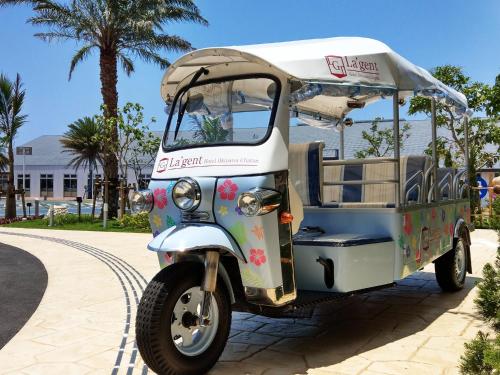 a small golf cart parked on a sidewalk at La'gent Hotel Okinawa Chatan Hotel and Hostel in Chatan