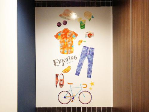 a picture of clothes and a bike on a wall at La'gent Hotel Okinawa Chatan Hotel and Hostel in Chatan