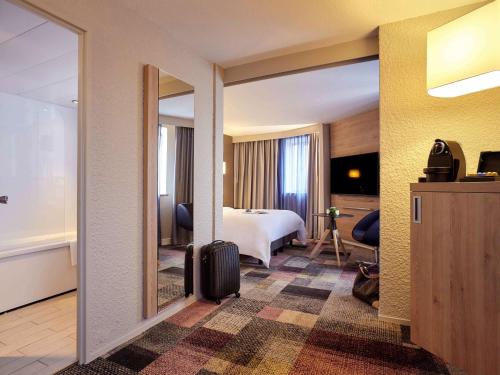 a hotel room with a bed and a large mirror at Mercure Le Havre Centre Bassin Du Commerce in Le Havre
