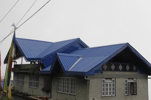 a blue roof on top of a house at Vamoose Sherpa Homestay in Ravangla
