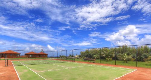 a tennis court with a tennis net on at Endeavour Lodge in Burnt Pine