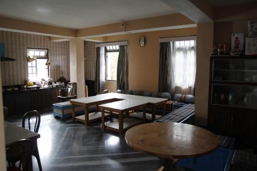 sala de estar con mesas y sofá en Vamoose Sherpa Homestay, en Ravangla
