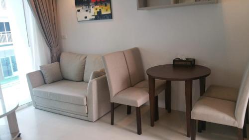 a living room with a couch and a table and chairs at GrandBlue Condominium 201 in Mae Pim