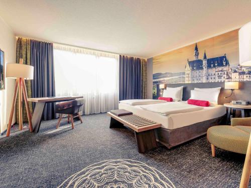 a hotel room with a large bed and a desk at Mercure München City Center in Munich