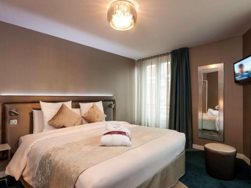 a bedroom with a large bed with a stuffed animal on it at Mercure Paris Place d'Italie in Paris