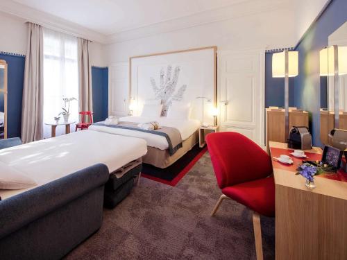 a hotel room with two beds and a red chair at Mercure Lyon Centre Château Perrache in Lyon