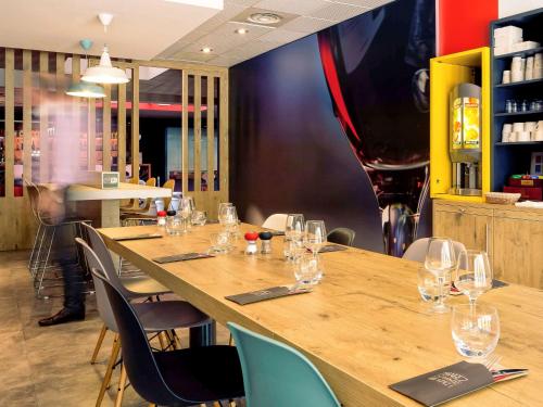 a large wooden table with wine glasses on it at ibis Lyon Part Dieu Les Halles in Lyon