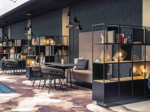 a room with a table and chairs and bookshelves at Hotel Mercure Blois Centre in Blois