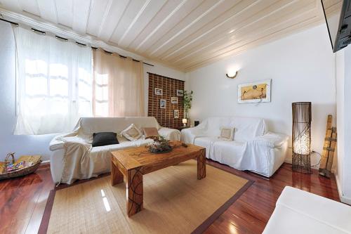 a living room with a white couch and a table at Villa Ti caz do miel avec piscine et bassin de détente à remous au Tampon pour 8 personnes in Le Tampon