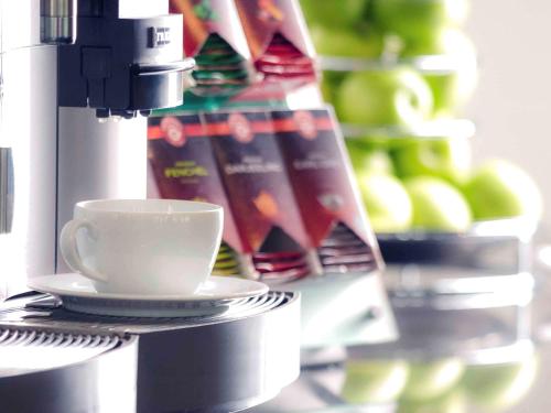 a coffee cup sitting on top of a coffee machine at Mercure Hotel Hagen in Hagen