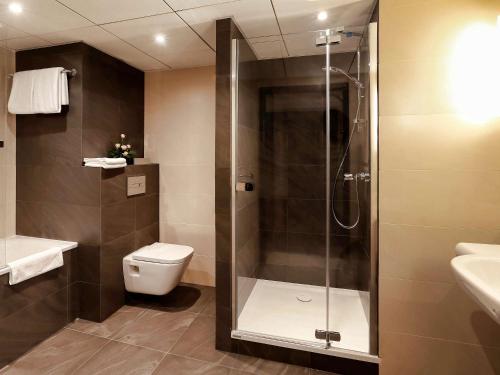 a bathroom with a shower and a toilet and a sink at Mercure Gdynia Centrum in Gdynia