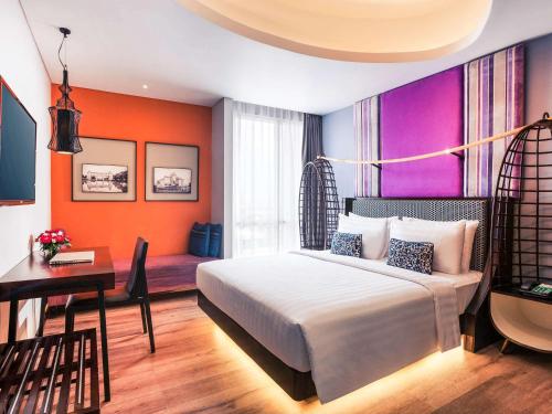 a bedroom with a bed and a desk and a desk at Mercure Surabaya Grand Mirama in Surabaya