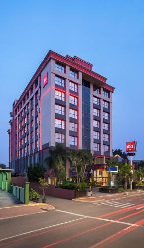 a large building on a city street next to a road at Ibis Kemayoran in Jakarta