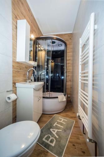 a bathroom with a toilet and a sink and a shower at Apartments Osijek by the River in Osijek