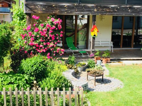 einen Garten mit rosa Blumen vor einem Haus in der Unterkunft Ferienwohnung Dünser in Bezau