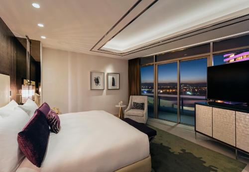 a hotel room with a large bed and a television at The Darling at The Star Gold Coast in Gold Coast