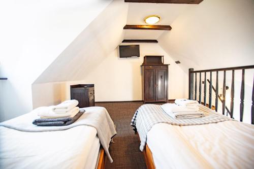 two twin beds in a room with a staircase at Gospoda pod Czarnym Łabędziem in Rydzewo