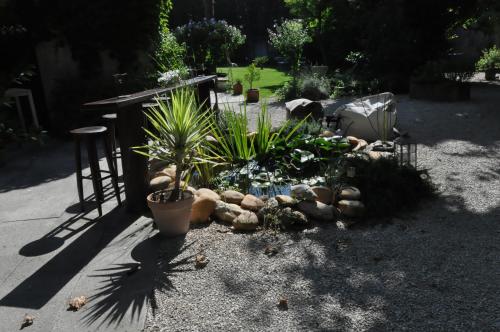 a garden with potted plants and a table at La demeure in Eyguières