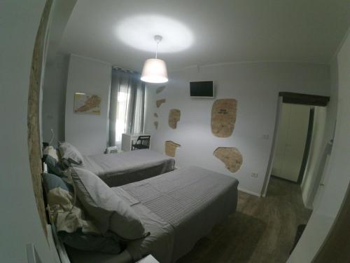 a small bedroom with two beds and a mirror at Isi GuestHouse in Iesi