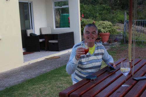 a man sitting at a picnic table holding a wine glass at Richards Travel Lodge in Jamestown