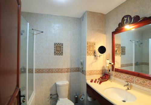 y baño con aseo, lavabo y ducha. en Elruha Hotel, en Sanlıurfa