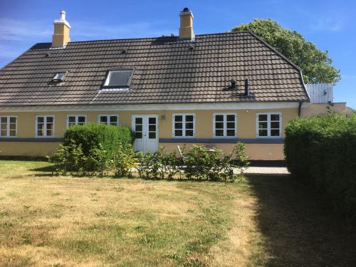a large yellow house with a roof at Thurø Rev Guesthouse in Svendborg