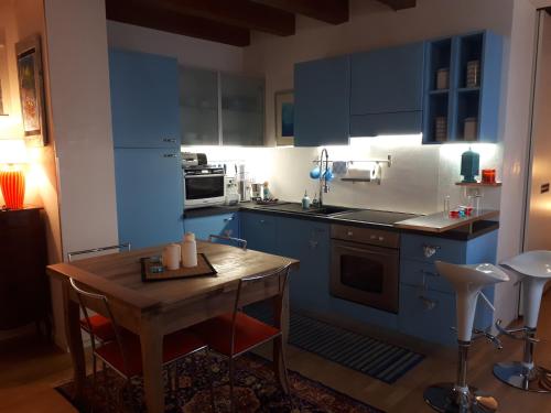 cocina con armarios azules y mesa de madera en Mini Contrà San Pietro, en Vicenza