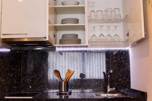 a kitchen with a sink and a counter with dishes at BLUESEA Dimona Suites in Torremolinos