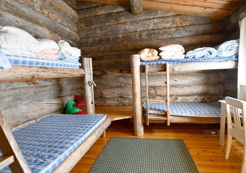 a room with three bunk beds in a log cabin at Rantaruka 1A3 in Ruka