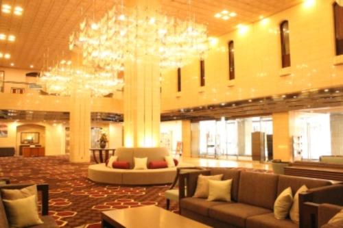 a large lobby with couches and a chandelier at Hotel Grand Terrace Toyama in Toyama