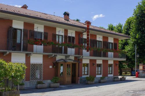 un edificio in mattoni rossi con fiori sui balconi di Ristorante Buasca a Cuorgnè