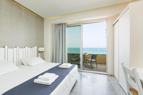 a bedroom with two beds and a view of the ocean at Meltemi Coast Suites in Rethymno Town